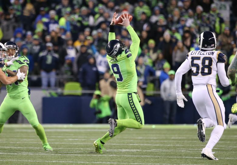 Seattle Seahawks punter Jon Ryan (9) bobbles the ball while running for 26  yards on a fake punt against the Los Angles Rams at CenturyLink Field in  Seattle, Washington on December 15