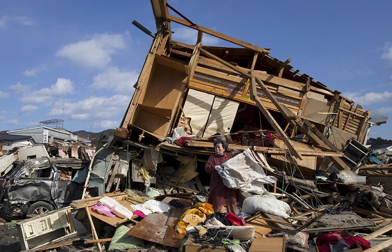 KESENNUMA, JAPAN – MARCH 18:  Aiko Musashi collects personnel belongings from her destroyed home on March 18, 2011 in Kesennuma, Japan. Thousands have been killed as a result of the 9.0 earthquake and consequent tsunami that struck the northeast coast of Japan six days ago. A potential humanitarian crisis looms as nearly half a million people who have been displaced by the disaster continue to suffer a shortage of food and fuel as freezing weather conditions set in.  (Photo by Paula Bronstein/Getty Images) 110166894