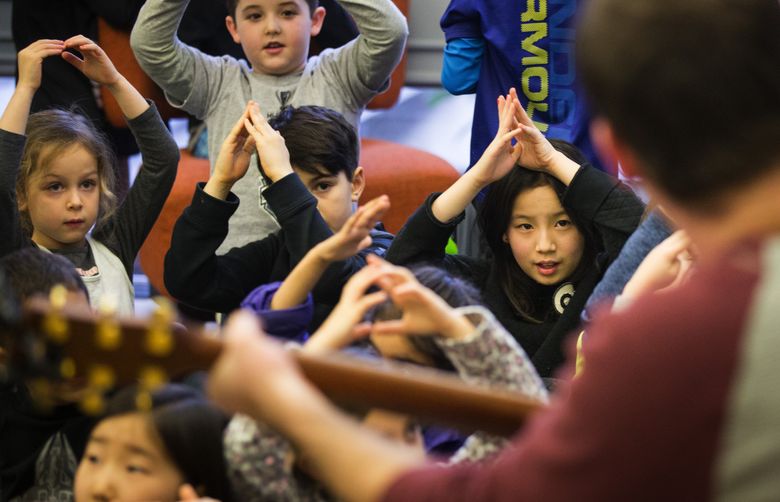 Kids sing along to a mashup of songs performed by camp director Josh Niehaus at the Stroum Jewish Community Center on Mercer Island during a Hanukkah gathering on Wednesday, Dec. 28, 2016. While “menorah” is the Hebrew phrase for any man-made light, “hanukkiah” specifically refers to a menorah made for observing the holiday. The center will continue its gatherings at 3:30 p.m. through Friday.