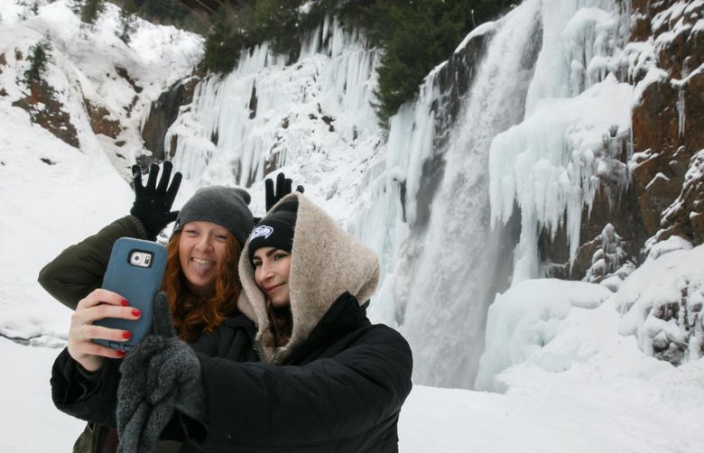 Holly Hunt, left, and Vanessa Steinberg, take photos at Franklin Falls outside of North Bend, Wash. Thursday, Dec. 22, 2016.
LO