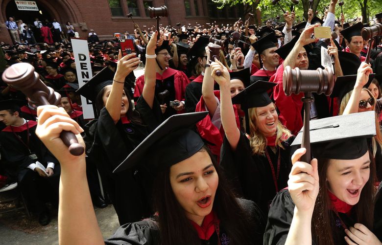 Sabreena Khalid, left, and Elizabeth Carthy, right, raise gavels as they celebrate graduating from Harvard Law School with classmates during Harvard University commencement exercises, Thursday, May 28, 2015, in Cambridge, Mass. (AP Photo/Steven Senne)