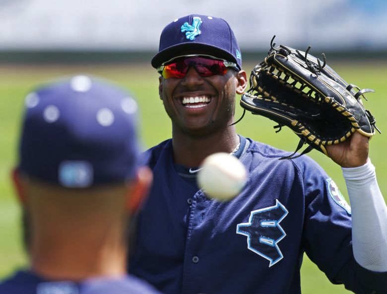 Seattle Mariners first-round draft pick Kyle Lewis holds up his