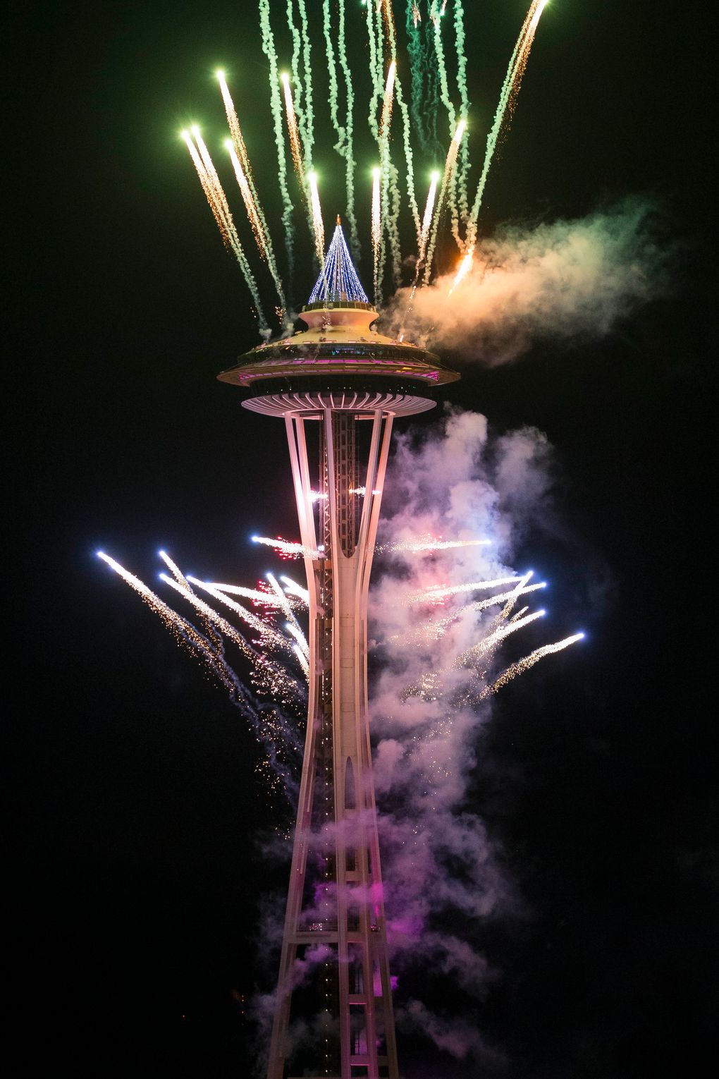 The first minutes of 2017 are celebrated with fireworks shot off of and around the Space Needle, as seen from the roof of Mbar restaurant on Sunday, January 1, 2017. (Logan Reily / The Seattle Times)