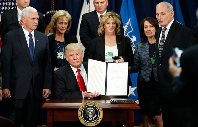 President Donald Trump, accompanied by Vice President Mike Pence, Homeland Security Secretary John F. Kelly, and others, holds up an executive order for immigration actions to build border wall, Wednesday, Jan. 25, 2017, atthe Homeland Security Department in Washington. (AP Photo/Pablo Martinez Monsivais)