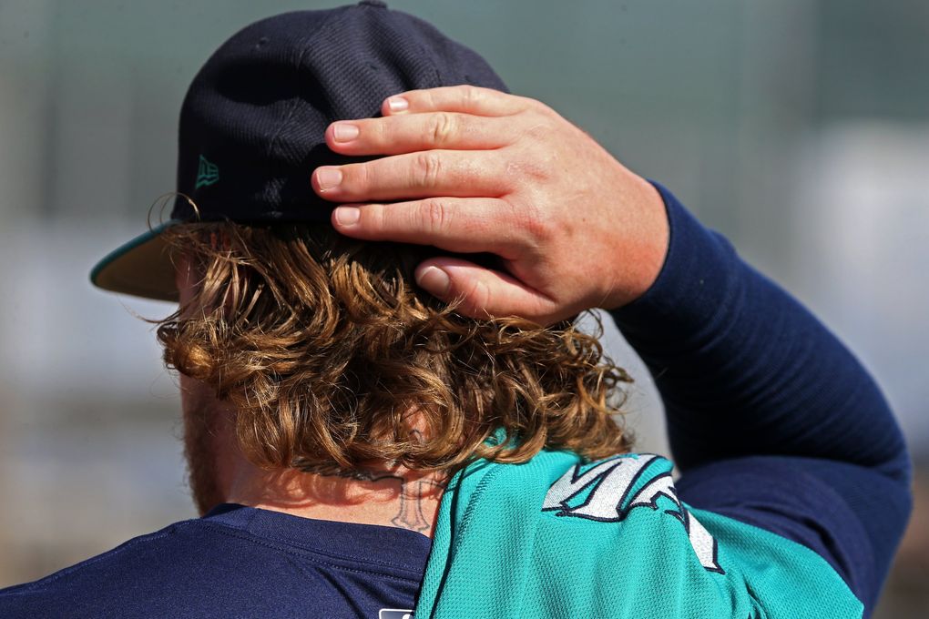 Dylan Unsworth slides his ballcap over long locks during Mariners spring training, Monday, Feb. 20, 2017, in Peoria, Ariz. (Ken Lambert / The Seattle Times)