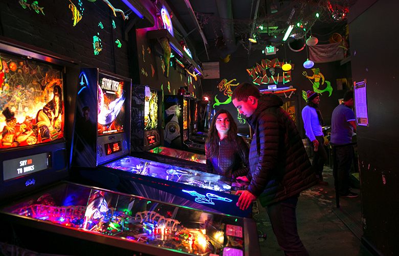(From left) Julia Lymar and Yanis Matison play pinball in the back room at Shorty’s in the Belltown neighborhood of Seattle on Tuesday, February 7, 2017.
