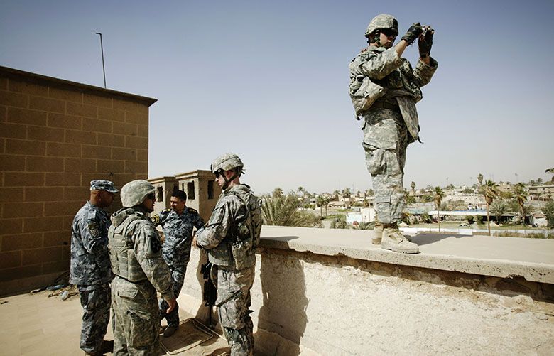 NO SALES – MAGS OUT – Maj. Brian Wortinger, forth from left, and the commander of the 2nd Battalion of the 1st Brigade of the Iraqi National Police, Col. Ayad Hamid Bahar Al-Utaibi, third from left, on the roof of the battalion’s new headquarters in a former embassy building in Baghdad’s central Karada district, May 2, 2009. An Iraqi interpreter, right, was asked by Wortinger to take some pictures of the compound for assessment. Iraq’s security forces, despite significant improvements, remain hobbled by shortages of men and equipment, by bureaucracy, corruption, political interference and security breaches that have resulted in the deaths of dozens of Iraqi and American troops already this year, according to officials from both countries. (Christoph Bangert/The New York Times) – MAGS OUT/NO SALES –