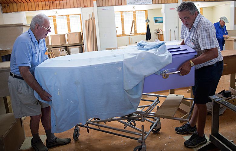 Roger Terry, left, and Phil Thompson move a completed coffin at the Hawke’s Bay D.I.Y. Coffin Club in Hawke’s Bay, New Zealand, Jan. 24, 2017. Coffin-building clubs have gained popularity among older New Zealanders looking beyond traditional social activities. (Lottie Hedley/The New York Times)
