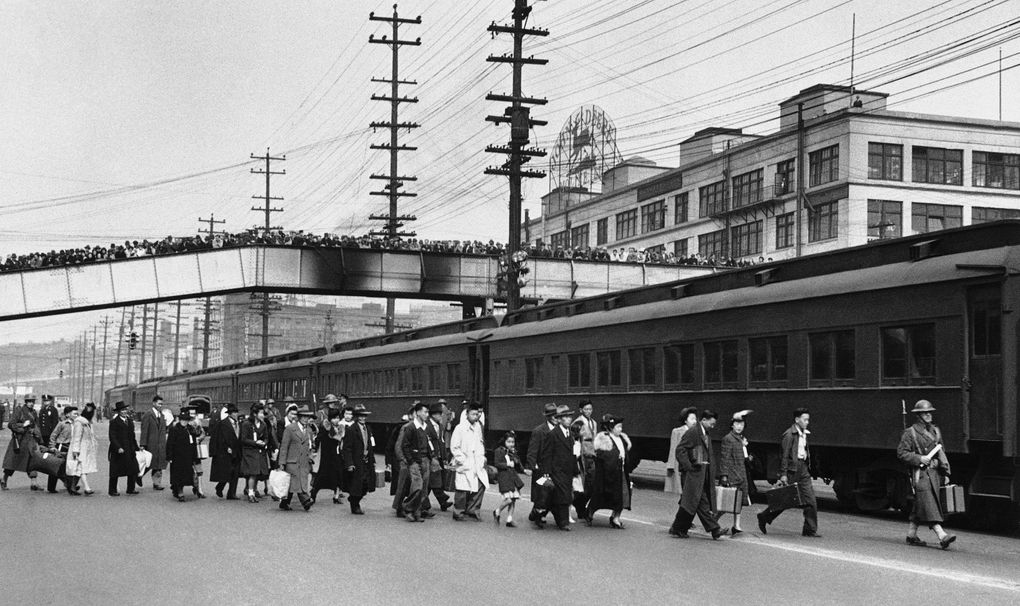 Seattle crowds jam an overhead walk to witness Japanese and Japanese Americans from Bainbridge Island as they walk to a train on March 30, 1942. (AP)