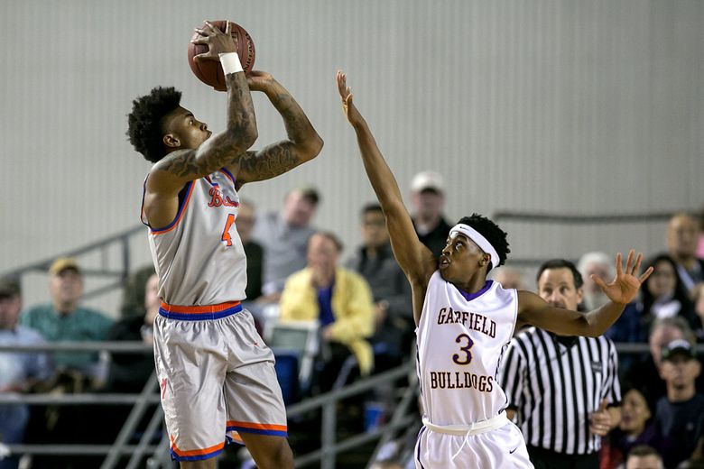 Kevin Porter, left, of Rainier Beach shoots over Edward Turner of Garfield during the first half. (Johnny Andrews / The Seattle Times)
