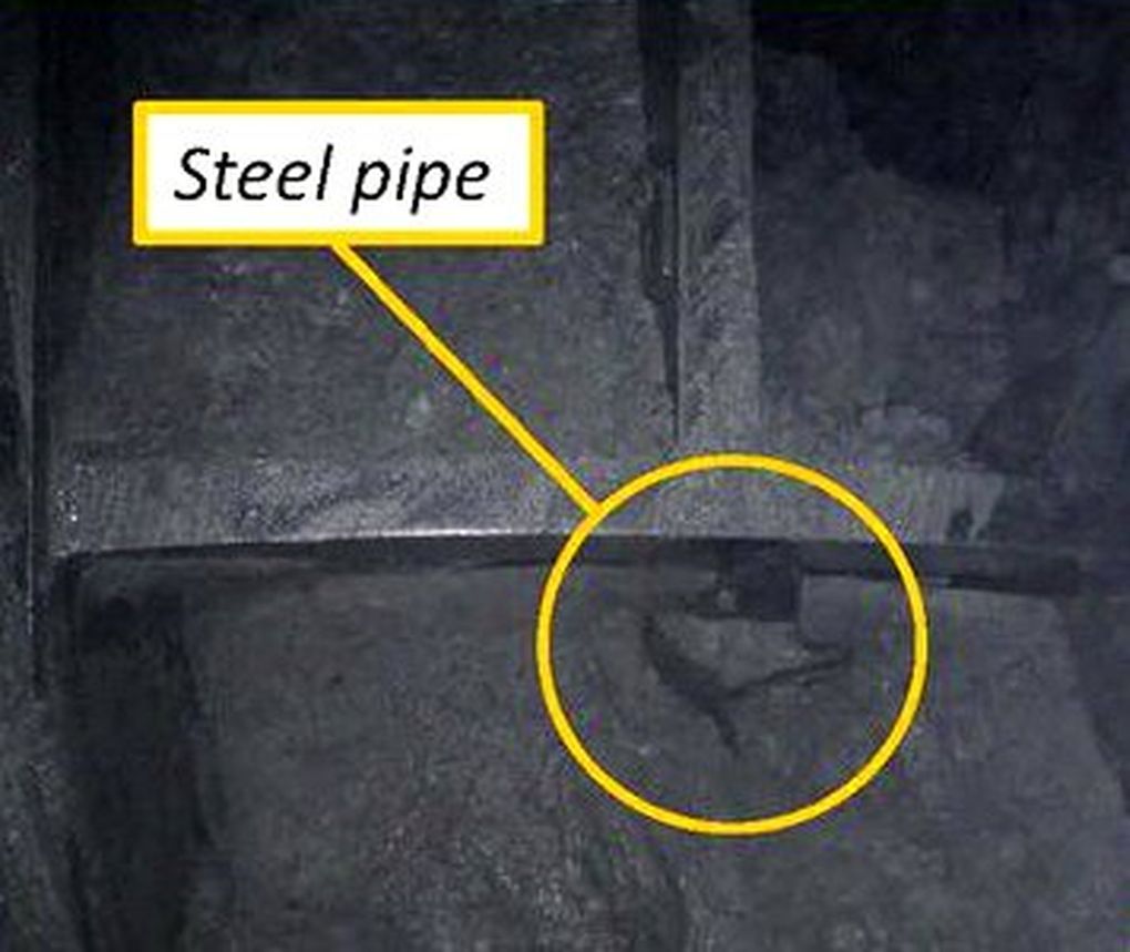 A fragment of steel pipe pokes between spokes of Bertha’s cutting face, in this photo from a January 2013 inspection. It’s part of a 119-foot deep well, left in the soil after a 2002 groundwater test. (Seattle Tunnel Partners)