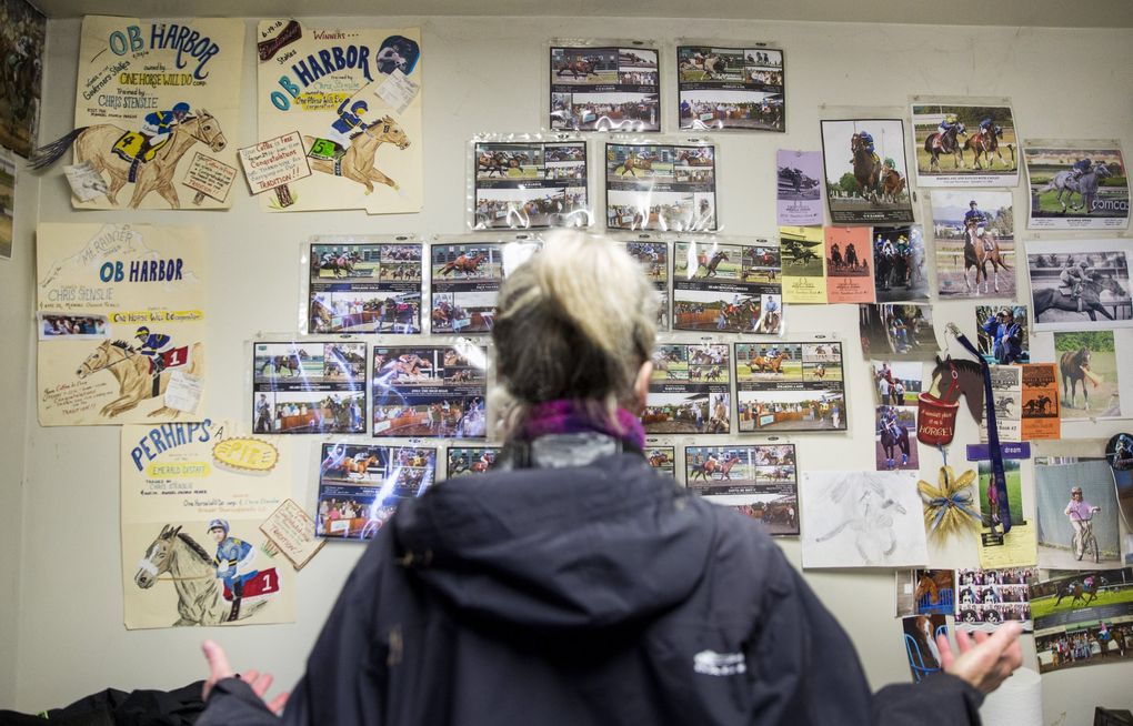 Jody Peetz has a wall of images of successes and heartbreaks in her office at Emerald Downs in Auburn. Peetz had both last year when her horse O B Harbor had a wonderfully successful season, but was later found dead in his stable from a twisted intestine. Peetz works with trainer Chris Stenslie to manage her stable, “One Horse Will Do.” (Bettina Hansen / The Seattle Times)