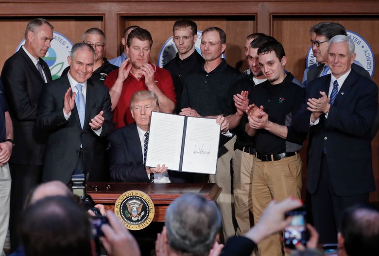 President Donald Trump, accompanied by coal miners and, from left, Interior Secretary Ryan Zinke, Environmental Protection Agency (EPA) Administrator Scott Pruitt, second from right, Energy Secretary Rick Perry, and Vice President Mike Pence, far right, holds up the signed Energy Independence Executive Order, Tuesday, March 28, 2017, at EPA headquarters in Washington. (AP Photo/Pablo Martinez Monsivais)