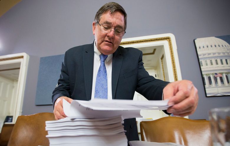 House Rules Committee member Rep. Michael C. Burgess, R-Texas, examines a printout of the $1.1 trillion spending bill to fund the government for the 2016 budget year and extend $680 billion in tax cuts for businesses and individuals, at the Capitol in Washington, Wednesday, Dec. 16, 2015.  President Barack Obama is expected to sign the legislation.  (AP Photo/J. Scott Applewhite)