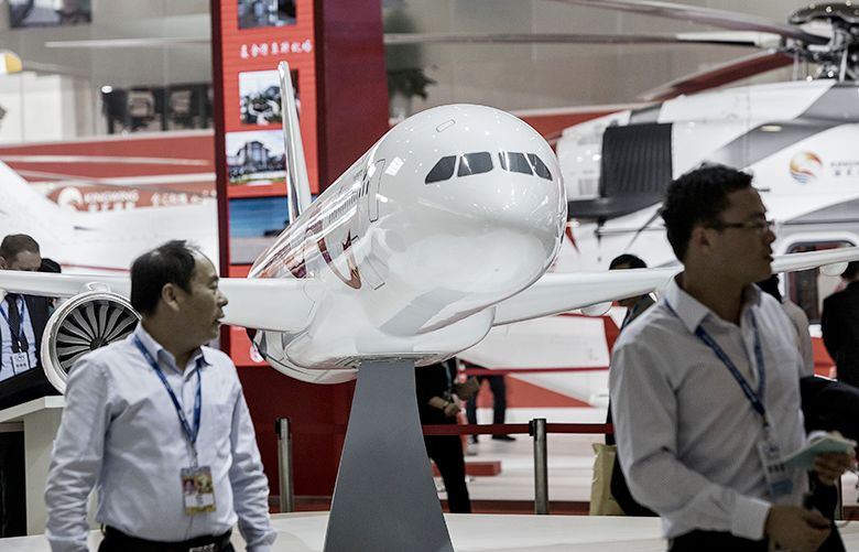 Visitors walk past a Commercial Aircraft Corp. of China (Comac) C919 model aircraft at the China International Aviation & Aerospace Exhibition in Zhuhai, China, on Tuesday, Nov. 1, 2016. The biannual air show runs from November 1 to 6. Photographer: Qilai Shen/Bloomberg