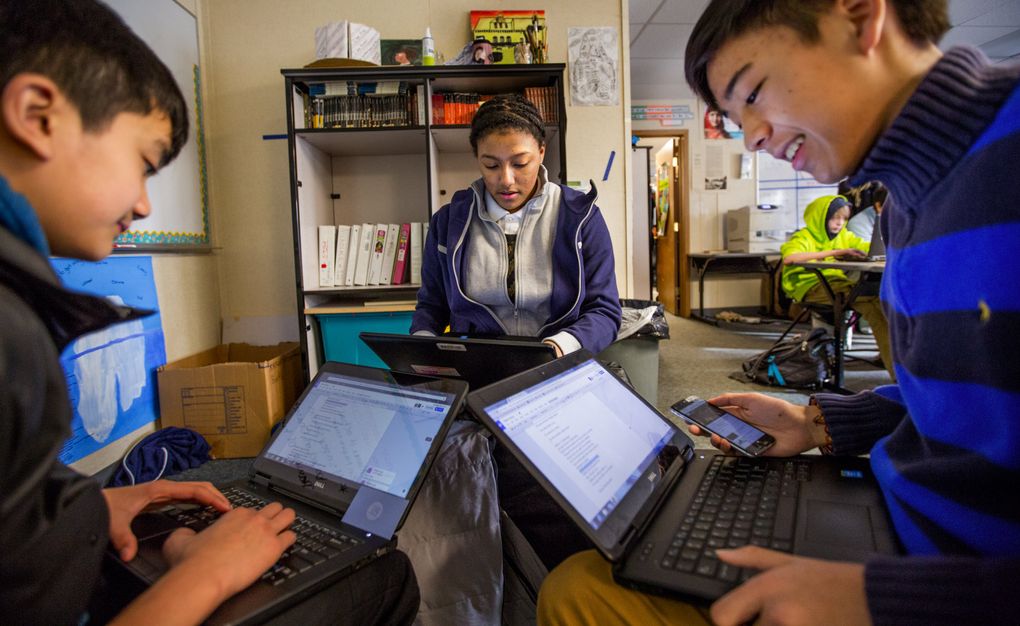 Eighth-grade TAF students Jesse Nguyen, left, Saana Banks and Nathan Calimlim work on creating a parody of a song that focuses on complaints during the Civil War. (Mike Siegel/The Seattle Times)