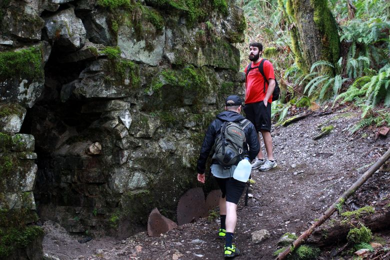 Jake Hoffman, left, and Tyler Godwin check out the historical lime kiln from which this hike receives its name. (Evan Bush / The Seattle Times)