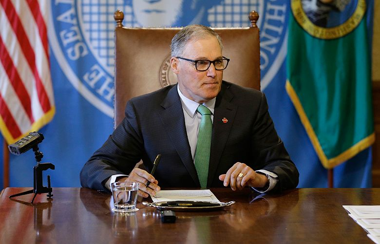 Washington Gov. Jay Inslee sits at a table prior to a bill-signing ceremony, Wednesday, April 19, 2017, at the Capitol in Olympia, Wash. (AP Photo/Ted S. Warren)