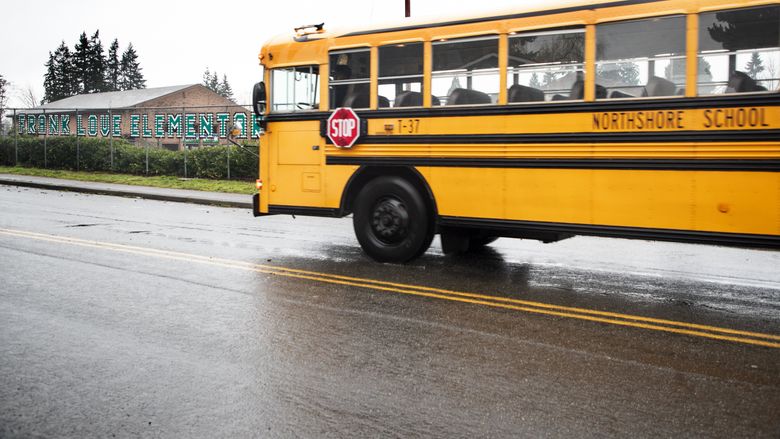 An empty Northshore School District school bus rolls past Frank Love Elementary