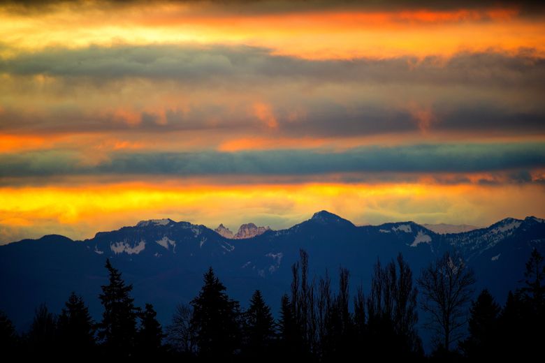 The Cascade Mountain range loom in front of Thrusday morning’s sunrise in this view from Seatac Washington. The weather forecast calls for decreasing chances of rain with highs in the mid 50s on Friday and partly sunny skies returning over the weekend. 
Photographed on January 10, 2019. 208990