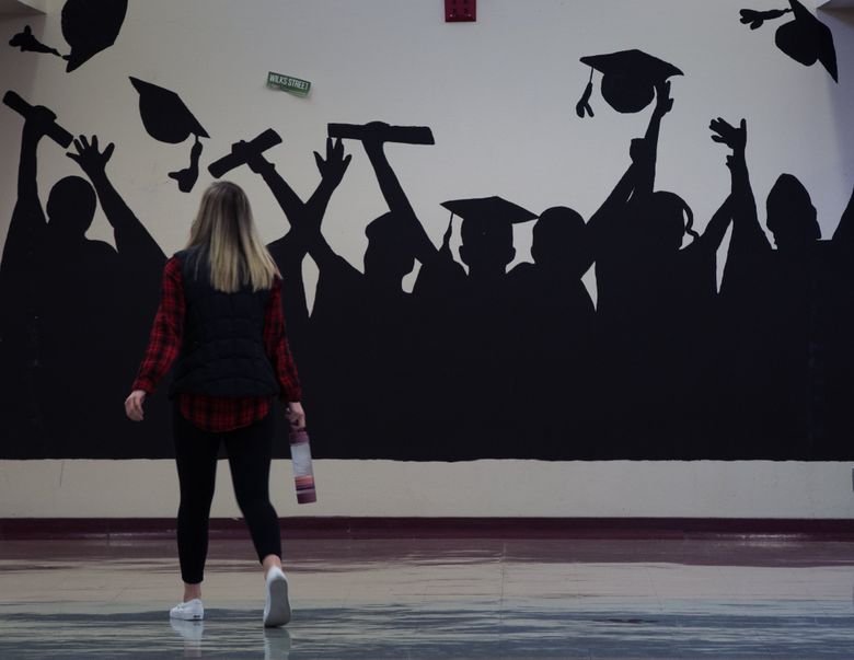 A student walks down a hallway decorated with a graduation silhouette at W.F. West High School. The Chehalis School District is revamping its culture in an effort to get more kids to go to college. With the help of a foundation and philanthropists who grew up there, it’s partnering with the local community college, Centralia College, to get more students to attend and finish higher education. The philanthropists behind it think it could be a model for the state.