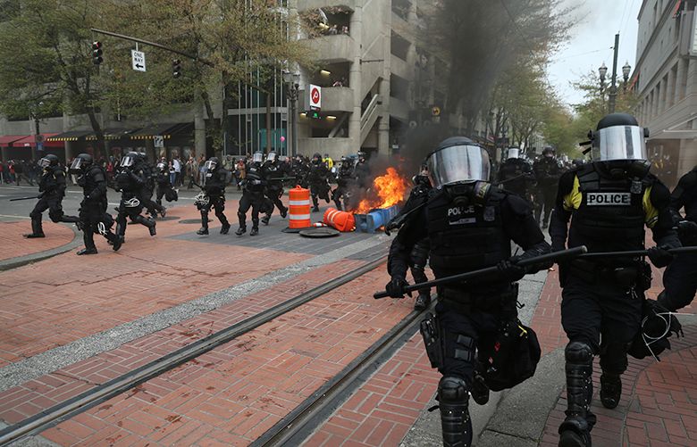Police disperse people participating in a May Day rally in downtown Portland, Ore., Monday, May 1, 2017. Police in Portland said the permit obtained for the May Day rally and march there was canceled as some marchers began throwing projectiles at officers. (Dave Killen/The Oregonian via AP)