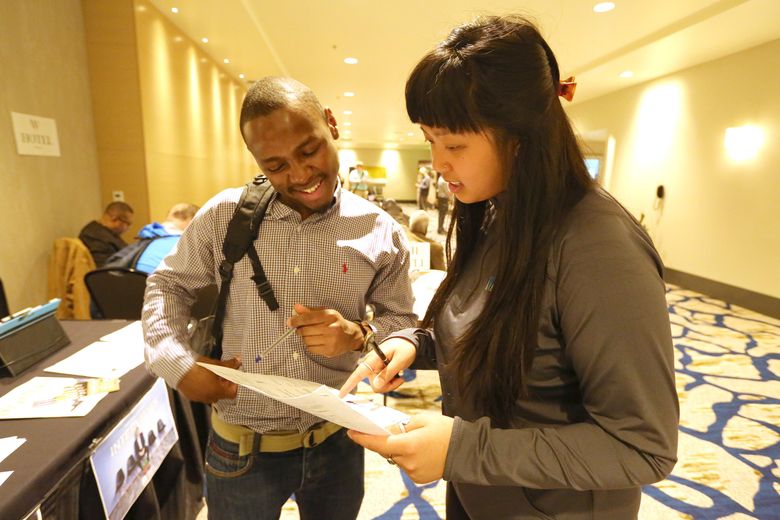 On Friday, May 5, 2017, at the Motif Hotel in downtown Seattle, Edwin Ngure,,30, (CQ), left, chats with Yen Huynh, (cq) with the Washington Hospitality Assn. They’re at a job fair hosted by WA Hospitality Assn, state Employment Security Office, WorkSource and others. Edwin hopes to land a job in the food service industry.