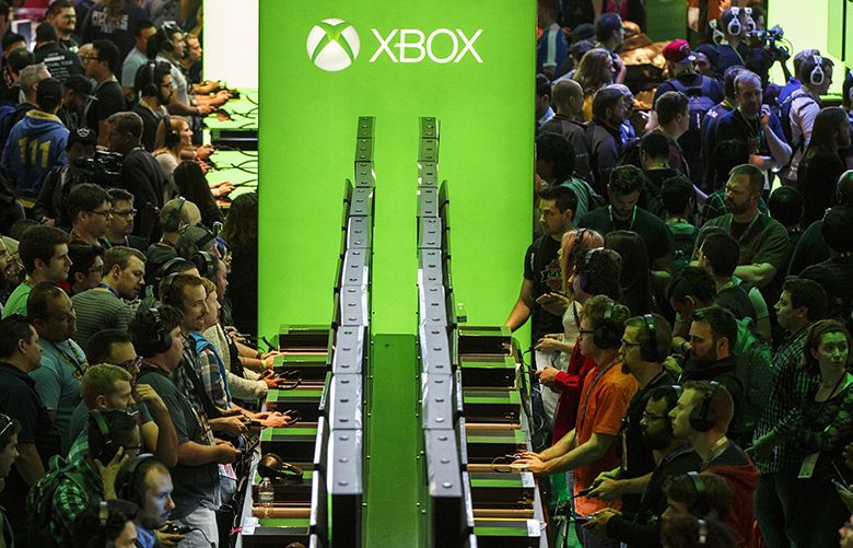 Attendees play Microsoft Corp. Xbox video games during the E3 Electronic Entertainment Expo in Los Angeles, California, U.S., on Wednesday, June 15, 2016. Microsoft Corp. introduced a new, smaller Xbox gaming console for sale in August and announced a powerhouse new device planned for the holiday season next year, ramping up its battle with Sony Corp. to win over hardcore gamers. Photographer: Patrick T. Fallon/Bloomberg