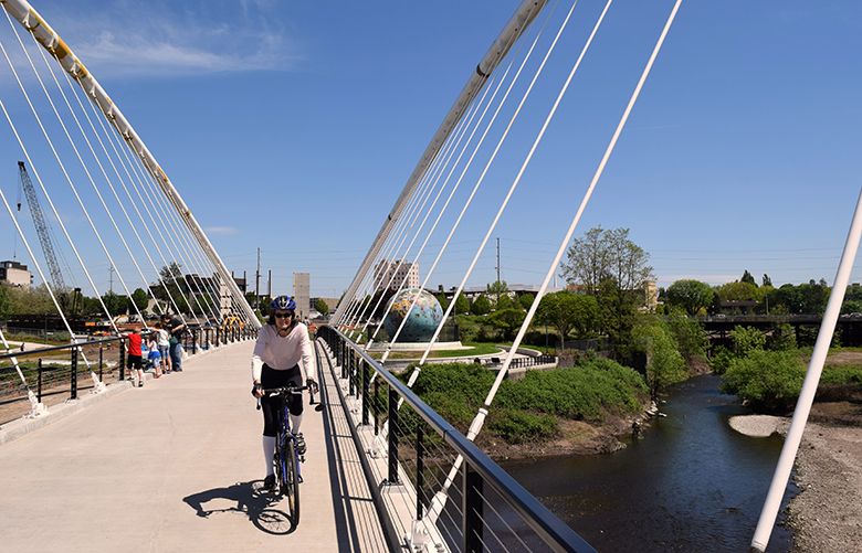 In Salem, Oregon, a new winged bridge for cyclists and pedestrians spans a Willamette River spur where salmon spawn and connects to Minto-Brown Island. Adjacent is the “Eco-Earth” globe, created from a repurposed acid-storage vessel for a former paper mill. Bill Thorness photo.