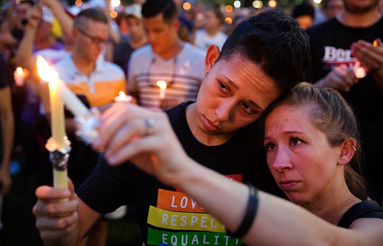 Jennifer, right, and Mary Ware light candles during a vigil downtown for the victims of a mass shooting at the Pulse nightclub Monday, June 13, 2016, in Orlando, Fla. A gunman has killed dozens of people in a massacre at a crowded gay nightclub in Orlando on Sunday, making it the deadliest mass shooting in modern U.S. history. (AP Photo/David Goldman)