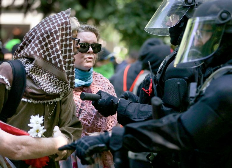 Police officers move to clear demonstrators from Chapman Square in downtown Portland on Sunday.  (Dave Killen/AP)