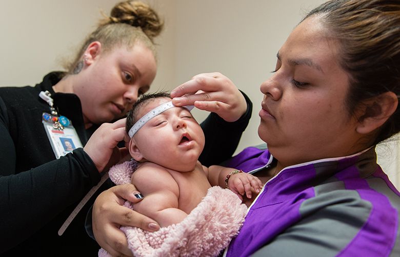 Jessica Rios holds niece Aryanna Guadalupe Sanchez-Rios as a technician measures her skull at Seattle Children’s Hospital in Seattle, WA., on May 5, 2017.  At 3 months, her head is still smaller than average. (Heidi de Marco/KHN)