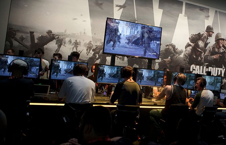 Attendees play the “Call Of Duty: WWII” video game by Activision Blizzard Inc. during the E3 Electronic Entertainment Expo in Los Angeles, California, U.S., on Tuesday, June 13, 2017. For three days, leading-edge companies, groundbreaking new technologies and never-before-seen products is showcased at E3. Photographer: Troy Harvey/Bloomberg