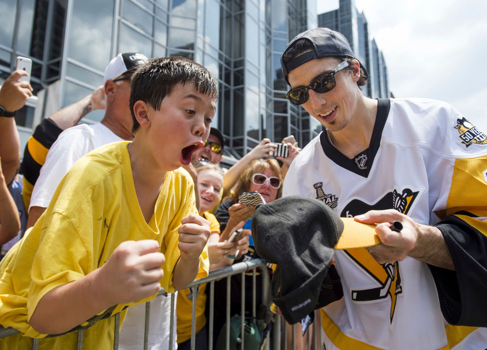 Pittsburgh Penguins center Sidney Crosby holds the Stanley Cup as fans  reach out to touch the trophy during the parade celebrating back to back Stanley  Cup victory in Pittsburgh on June 14