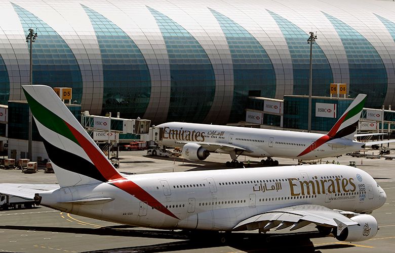 FILE- In this May 8, 2014 file photo, Emirates passenger planes are in use at Dubai airport in United Arab Emirates. Dubai Airports said Monday it plans to add 10 more A380 gates with air bridges at Dubai International Airport’s Concourse C. That will leave the airport with a world record 47 gates designed for the aircraft. (AP Photo/Kamran Jebreili, File)