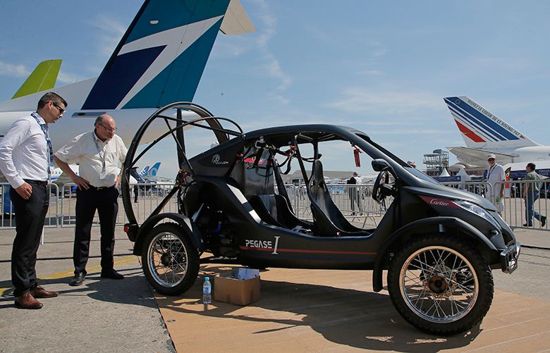 Visitors looks at the flying car Pegasus 1, built by French entrepreneur Jerome Dauffy at Paris Air Show, in Le Bourget, east of Paris, France, Tuesday, June 20, 2017 in Paris. Aviation professionals and spectators are expected at this week’s Paris Air Show, coming in, in a thousands from around the world to make business deals. (AP Photo/Michel Euler)