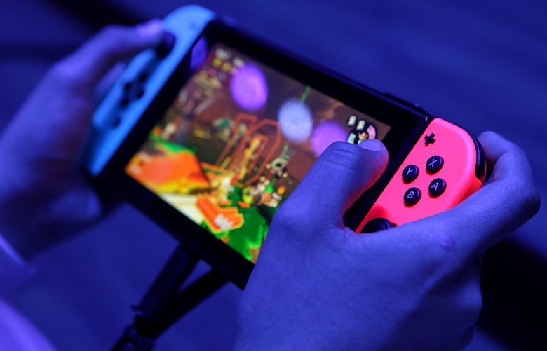 An attendee plays on a Nintendo Co. Switch video game console during the E3 Electronic Entertainment Expo in Los Angeles, California, U.S., on Wednesday, June 14, 2017. For three days, leading-edge companies, groundbreaking new technologies and never-before-seen products is showcased at E3. Photographer: Troy Harvey/Bloomberg