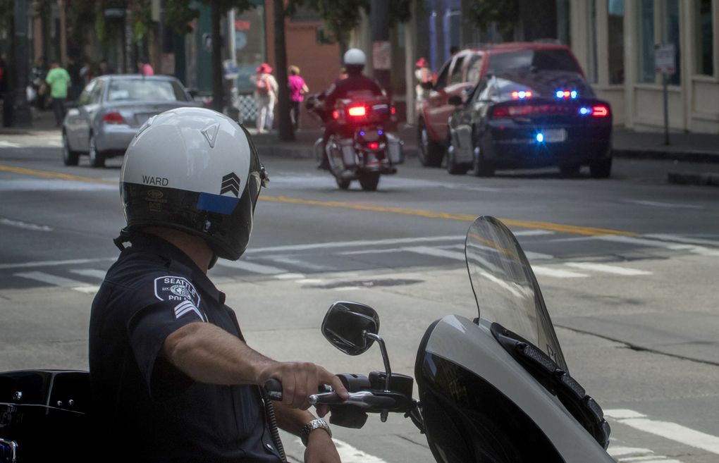 Sgt. Randy Ward, a Seattle Police Department officer, watches as officers pull over motorists on Third Avenue on Thursday. A downward trend in ticketing by Seattle Police Department is consistent across many types of infractions, a data analysis shows. (Ellen M. Banner / The Seattle Times)