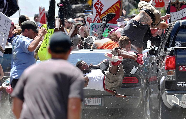 People fly into the air as a vehicle drives into a group of protesters demonstrating against a white nationalist rally in Charlottesville, Va., Saturday, Aug. 12, 2017. (Ryan M. Kelly/The Daily Progress via AP)