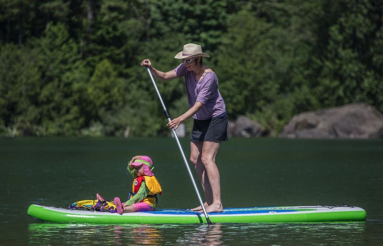 Thursday, June 29, 2017.   Pacific Story.   Margaret Wheeler paddleboards with a passerger onboardâ€”her two-year-old daughter on Rattlesnake Lake near North Bend. Margaret and her husband Matt Farmer are both mountain guides in the US and Europe.