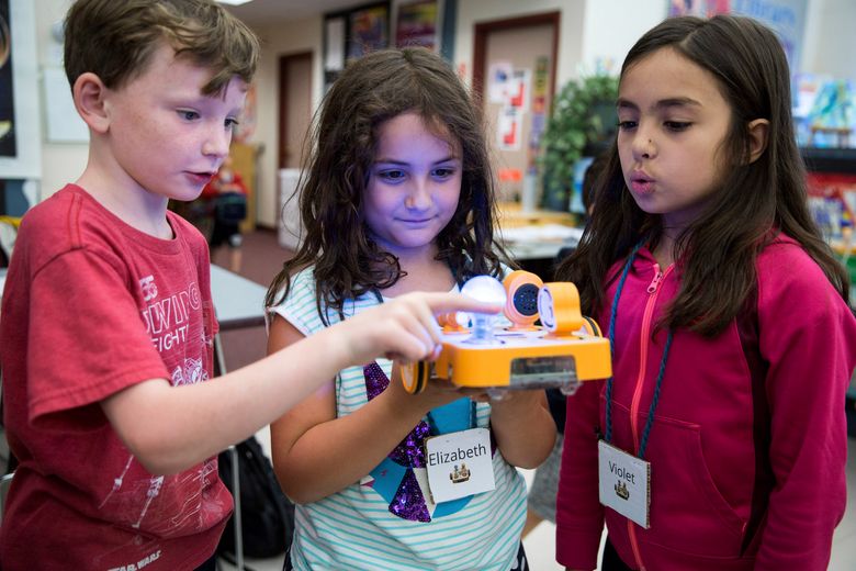 From left: Declan Lewis, 8, Elizabeth Sheldon, 7, and Violet Smith, 7, with a KIBO robot at DevTech summer camp, Tufts University in Medford, Mass., July 24, 2017. The robot can light up and make sounds in response to a child’s building a line of code with the programmable blocks. (Kayana Szymczak/The New York Times)