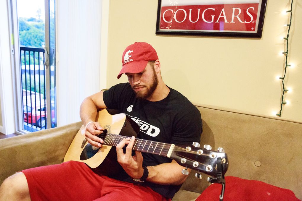 Linebacker Isaac Dotson shares a few of his guitar tunes at his apartment in Pullman, Wash. Wednesday July 5, 2017. Dotson, who loves listening to music and composing his own songs, lives with several seniors and a junior on the WSU football team. (Erika Schultz / The Seattle Times)