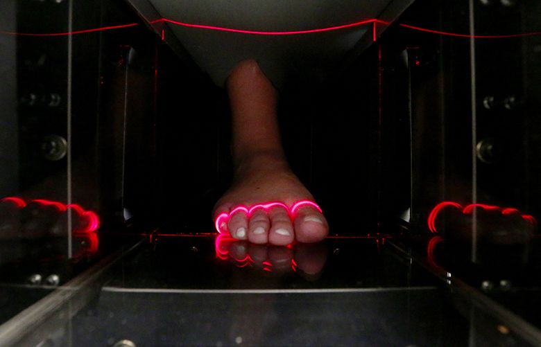 A foot is scanned by a medical device to gather data to eventually feed into a 3D printer at Prevolve, a shoe company that makes running/walking shoes using 3D printing, Wednesday, July 19, 2017, Seattle.