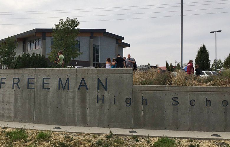 People gather outside of Freeman High School after reports of a shooting at the school in Rockford, Wash., Wednesday, Sept. 13, 2017. (KHQ via AP) NYAG311 NYAG311