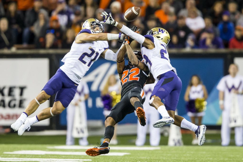 Washington defensive backs Taylor Rapp, left, and Jordan Miller, right, break up a pass intended for Oregon State wide receiver Seth Collins as the University of Washington Huskies take on the Oregon State Beavers at Reser Stadium in Corvallis, Oregon Saturday. (Bettina Hansen / The Seattle Times)
