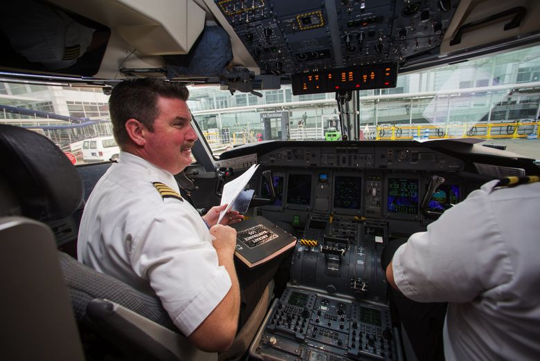 Horizon Air Capt. Ryan Braden, left, and First Officer Alex Schweitzer go over a checklist before they take off for Wenatchee in a Horizon Air Q400 turboprop. (Ellen M. Banner/The Seattle Times)