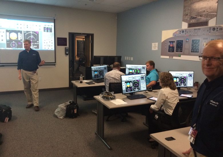 Newly hired pilots train inside a classroom at Horizon Air’s operations center at Portland International Airport. They are learning to use navigation systems that allow them to fly into small airports with difficult approaches. (Dominic Gates/The Seattle Times)