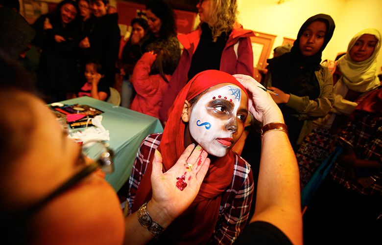Anita Sharif of South Seattle, gets her face painted by first year artist Raquel Garcia during the 12th annual Dia De Los Muetos celebration held at the El Centro de la Raza in Beacon Hill on Tuesday, November 1, 2016. This yearâ€™s Day of the Dead theme draws attention to systematic racial inequities and calls on people to exercise their right to vote in honor of those who have lost their lives.