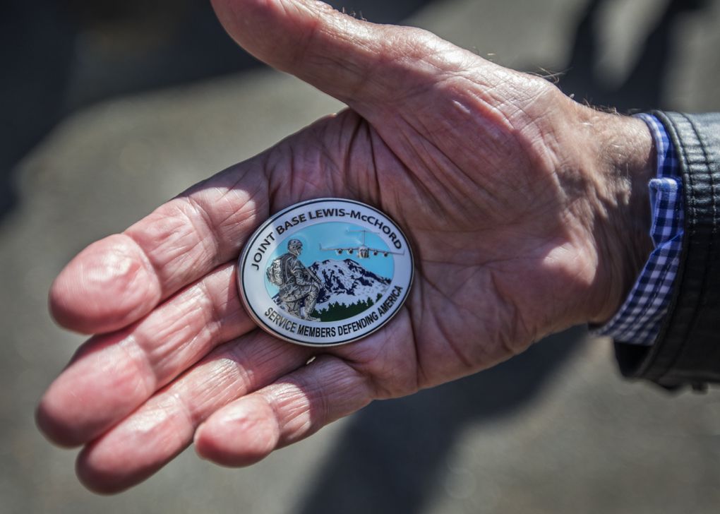 Günter Gräwe shows off a commemorative item given to him during his visit to JBLM this month. (Steve Ringman/The Seattle Times)
