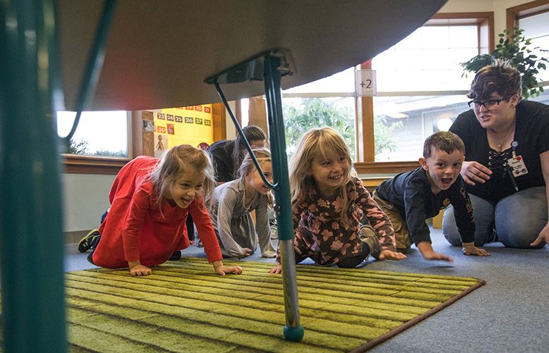 Friday, October 13, 2017.  Pre-schoolers at the Martha & Mary KIDS child Care Center in Poulsbo rush to take cover under tables after Heather Beal had read them a book on earthquakes.  Teacher Chelby Williams is at right.